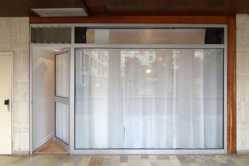 une grande porte coulissante en verre avec un rideau blanc dans l'établissement Fully equiped flat with air conditioning, à Paris
