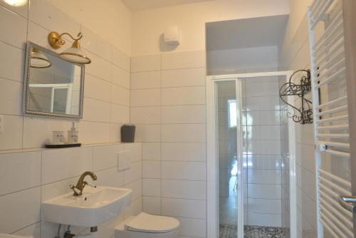 bagno con lavandino, servizi igienici e specchio di Apartmány MANDLE a Hustopeče