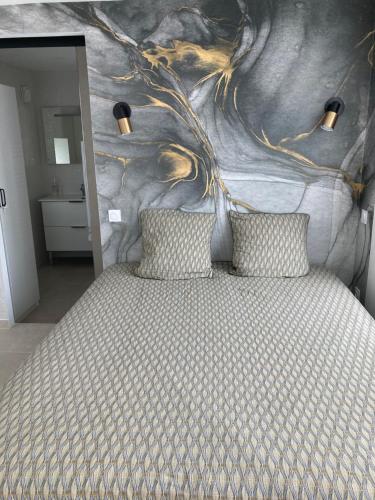 a bedroom with a bed with a painting on the wall at L'Etape, logement climatisé ! in Beire-le-Châtel