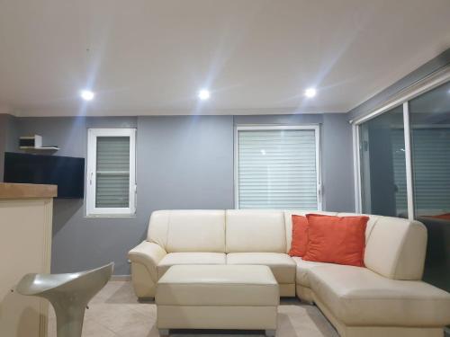 sala de estar con sofá blanco y almohada roja en Modern Studio Apartment with Garden en Ayvalık