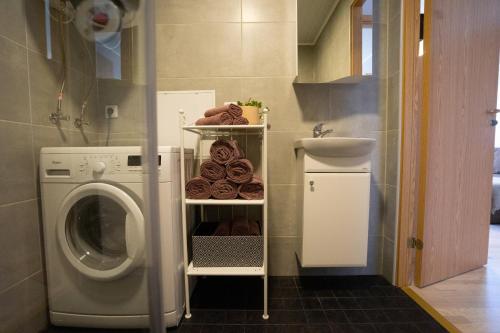 a laundry room with a washing machine and a rack of donuts at Lavender House in Kuressaare