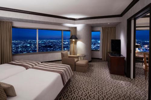 Cette chambre comprend un grand lit et un bureau. dans l'établissement Yokohama Royal Park Hotel, à Yokohama