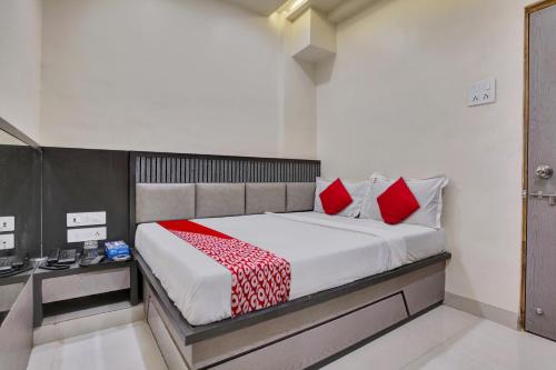 1 dormitorio con 1 cama grande con almohadas rojas en Hotel Dhiman Residency en Bombay