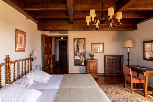 a bedroom with a bed and a desk and a table at Parador de Verín in Monterrei