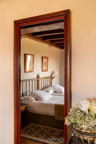 a mirror reflection of a bed in a bedroom at Parador de Verín in Monterrei