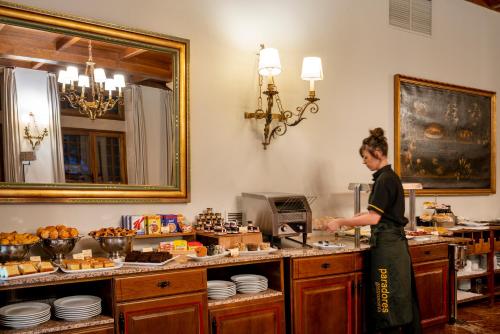 a man standing in a kitchen preparing food at Parador de Verín in Monterrei