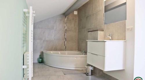 ein Badezimmer mit einer weißen Badewanne und einem Waschbecken in der Unterkunft au gite de la cascade in Le Grand Serre