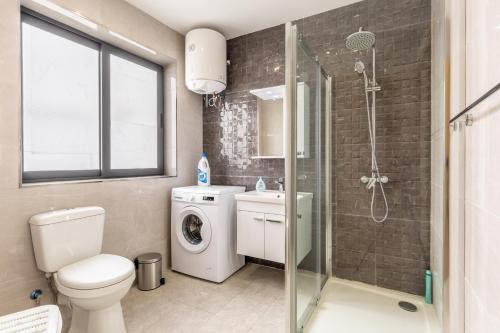 uma casa de banho com um lavatório e um chuveiro. em New top floor apartment enjoy opening views em San Ġwann