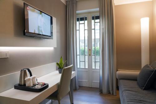 a living room with a table and a tv on a wall at Hotel Residence Esplanade in Viareggio