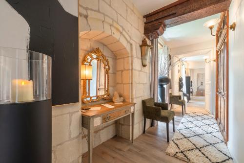 Cette chambre comprend une coiffeuse avec un miroir et une chaise. dans l'établissement Château de la Ronde - Avec piscine et jacuzzi, à Vivy