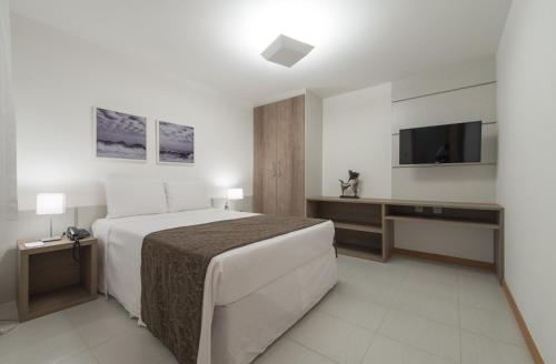 Habitación de hotel con cama y TV en Promenade Prime Itaboraí en Itaboraí