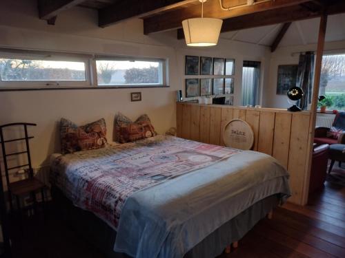 a bedroom with a large bed in a room with windows at Holiday cottage de Garage Inn in Hank