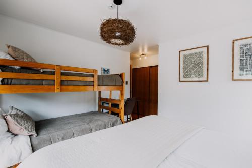 1 dormitorio con litera y silla en Family Home with Pool Gardin and Quincho, en Algarrobo