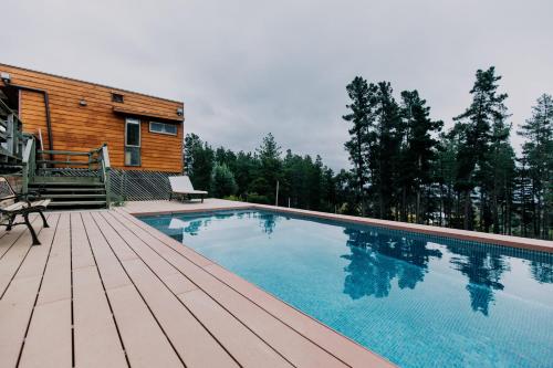 una piscina en una terraza de madera junto a una casa en Family Home with Pool Gardin and Quincho, en Algarrobo