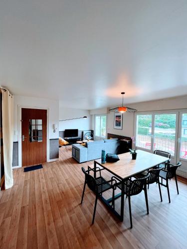 un salon avec une table, des chaises et un canapé dans l'établissement Traezh ar vag - Appartement Plage Perros-Guirec, à Perros-Guirec