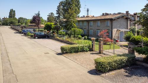 ein Haus mit Autos, die vor einer Einfahrt geparkt sind in der Unterkunft Residence Antico Borgo in Modena