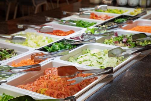 a buffet filled with trays of vegetables and other foods at Prestige Goya Park in Roses