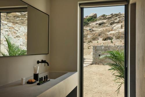 a bathroom with a sink and a mirror at Naxian Rhapsody in Stelida