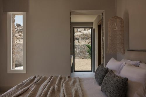 a bedroom with a bed and a door with a window at Naxian Rhapsody in Stelida