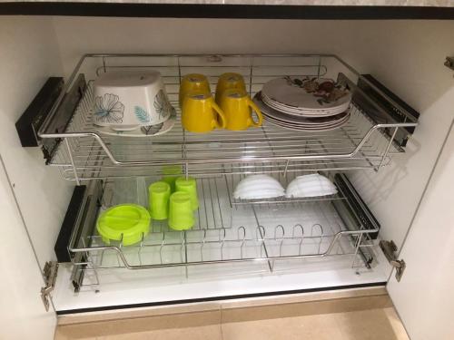 a shelf in a refrigerator filled with dishes and shoes at HOMESTAY CIK PHIA in Kuala Terengganu