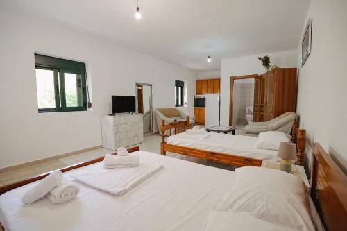 a bedroom with two beds and a living room at Green Villa in Sarandë