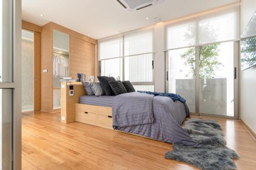 Ban Pak LakにあるExquisite Pool Residence A19: Aesthetics and Luxury Combinedのベッドと大きな窓のある寝室