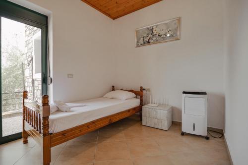 a bedroom with a bed and a window at Green Villa in Sarandë