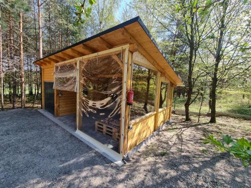 a small wooden shed with a large window at Domki Wzgórze Kamień in Józefów