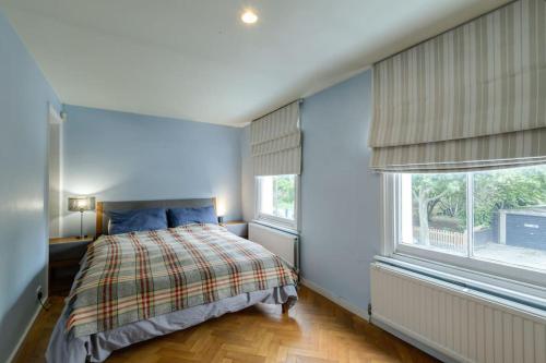 a bedroom with a bed and two windows at 1 bed Townhouse in Battersea close to River Thames in London