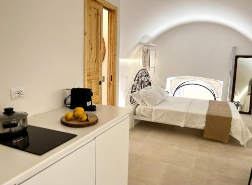 a kitchen with a bed and a table with fruit on a counter at Ruggine Loft in Gallipoli
