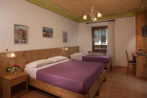 a hotel room with two beds and a table at Hotel Centrale in Alleghe