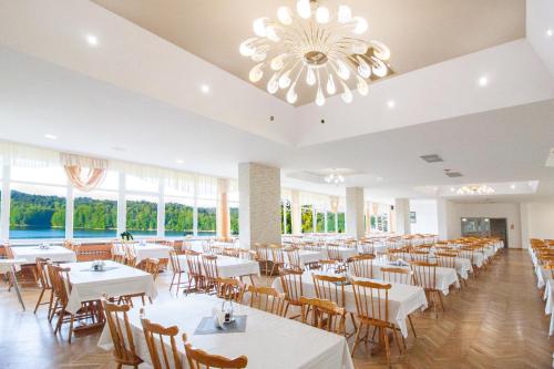 a dining room with tables and chairs and a chandelier at Rewita Solina in Solina