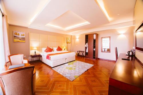 a large room with a bed and a desk and a table at Mount Royal Villa in Iringa