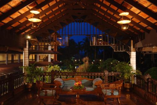 a patio with a couch and chairs and lights at The Raviz Kadavu, Kozhikode in Kozhikode