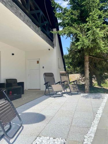 a group of chairs sitting on a patio at Farmhouse Dzeni in Vlasic