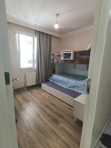 um quarto com um beliche e piso em madeira em Spacious and nice apartment em Avcılar
