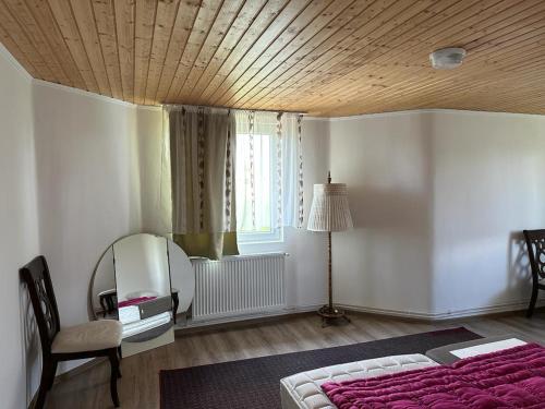 ein Schlafzimmer mit einem Bett, einem Stuhl und einem Fenster in der Unterkunft Közösségi ház 