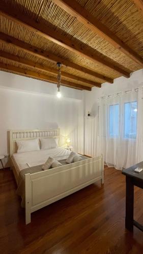 a bedroom with a large white bed with a wooden ceiling at Anthoula Home Paros in Naousa