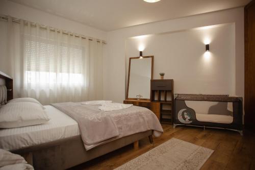 um quarto com uma cama, um espelho e uma televisão em 446 Luxury Apartament Center em Shkodër