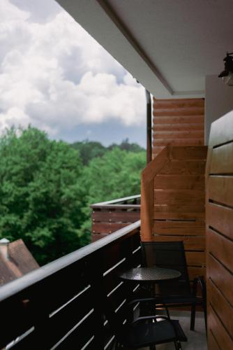 a balcony with a table and a chair and a window at Pensiunea Senin in Sovata