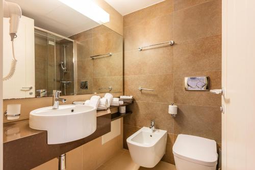 een badkamer met een wastafel en een toilet bij VOI Daniela Essentia in Conca Specchiulla