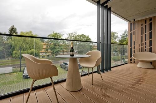 a balcony with a table and chairs and a bottle of wine at Apartamenty Wydma & Las BlueApart in Jastarnia