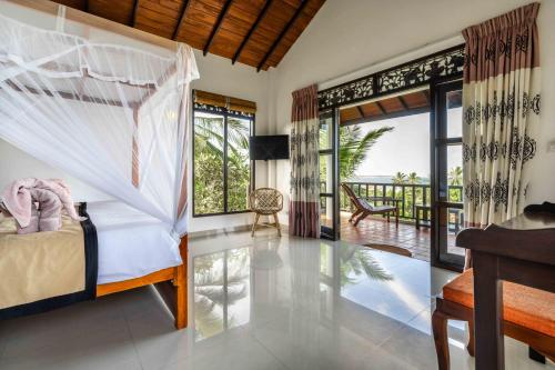 a bedroom with a bed and a view of the ocean at Ananthaya Beach in Tangalle
