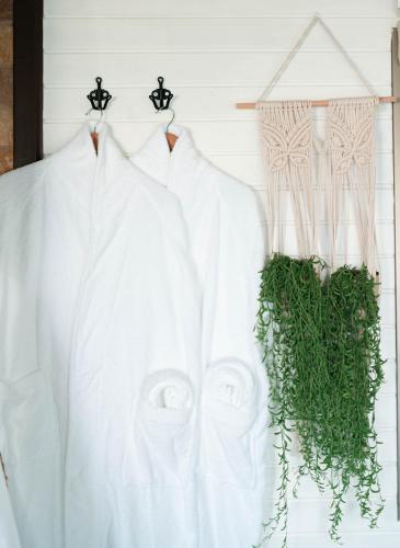 two white shirts hanging on a wall with plants at Live in the woods in Mikhmannim
