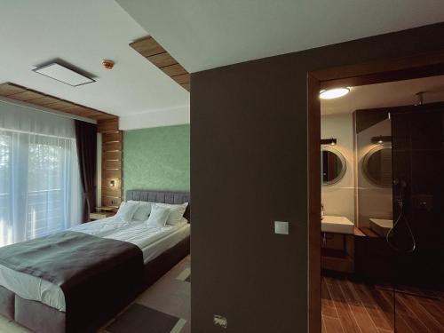 a hotel room with a bed and a mirror at Pensiunea Senin in Sovata
