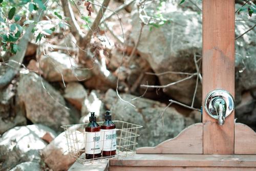 two bottles of wine in a basket on a table at Live in the woods in Mikhmannim