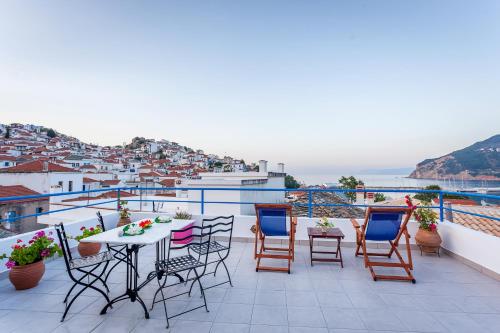 a balcony with a table and chairs and a view at Aggela Guesthouse in Skopelos Town