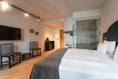 a hotel room with a bed and a flat screen tv at H5 Grauer Bär Studios & More in Innsbruck