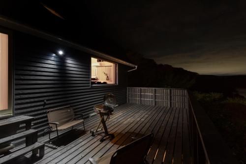 a wooden deck with a chair and a television on it at Villa Noël Hakone Fuji Sauna&Open Air Bath in Hakone