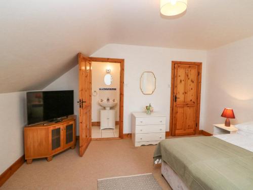 a bedroom with a bed and a flat screen tv at Coorlacka in Ballydivin